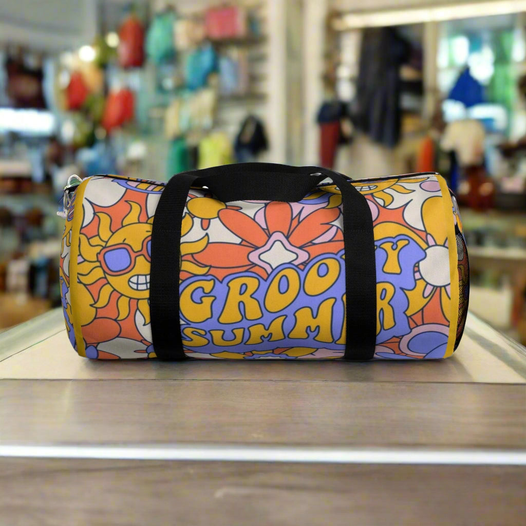 Colorful duffel bag with floral design and 'Groovy Summer' text on a white background