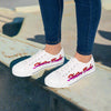 Women's Low Top Sneakers with Skater Babe lettering in pink and purple, designed by Leanne Roberts, on white canvas with blue jeans.