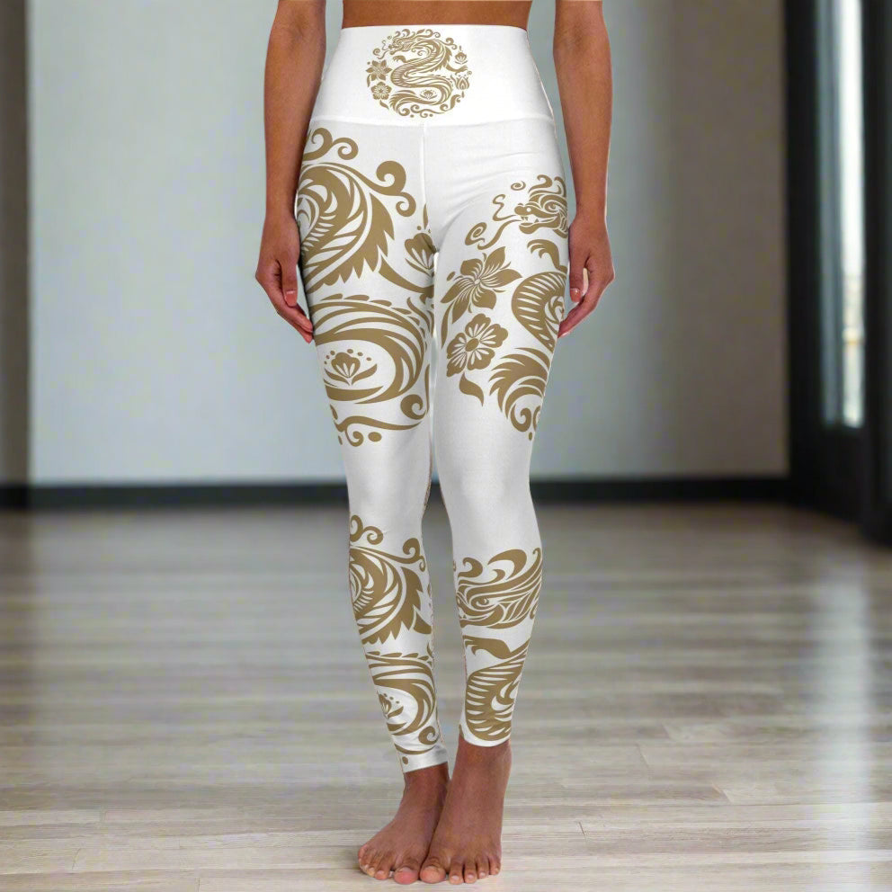 High waisted yoga leggings with white base and gold floral swirl print, featuring a high-rise waistband for comfort and flexible 4-way stretch fabric.