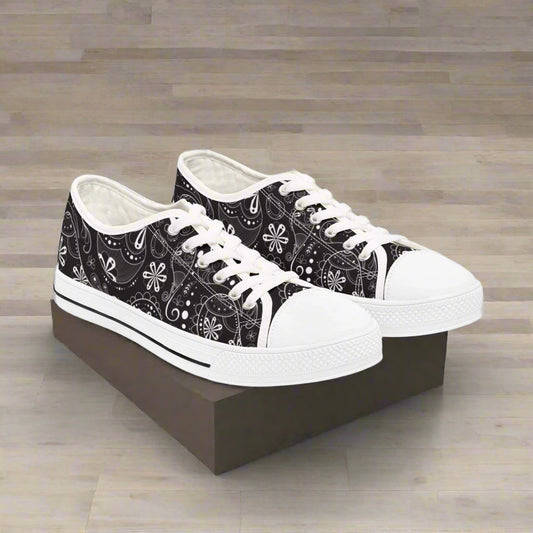 Boho floral women's low top sneakers with black and white floral pattern, white laces, and white rubber sole for casual everyday wear.