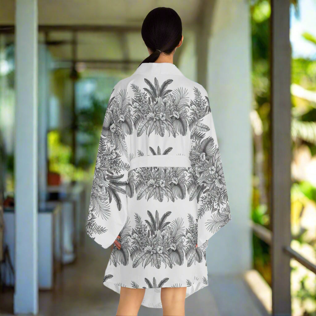 woman wearing chic black and white floral long sleeve kimono robe with tropical print standing on porch