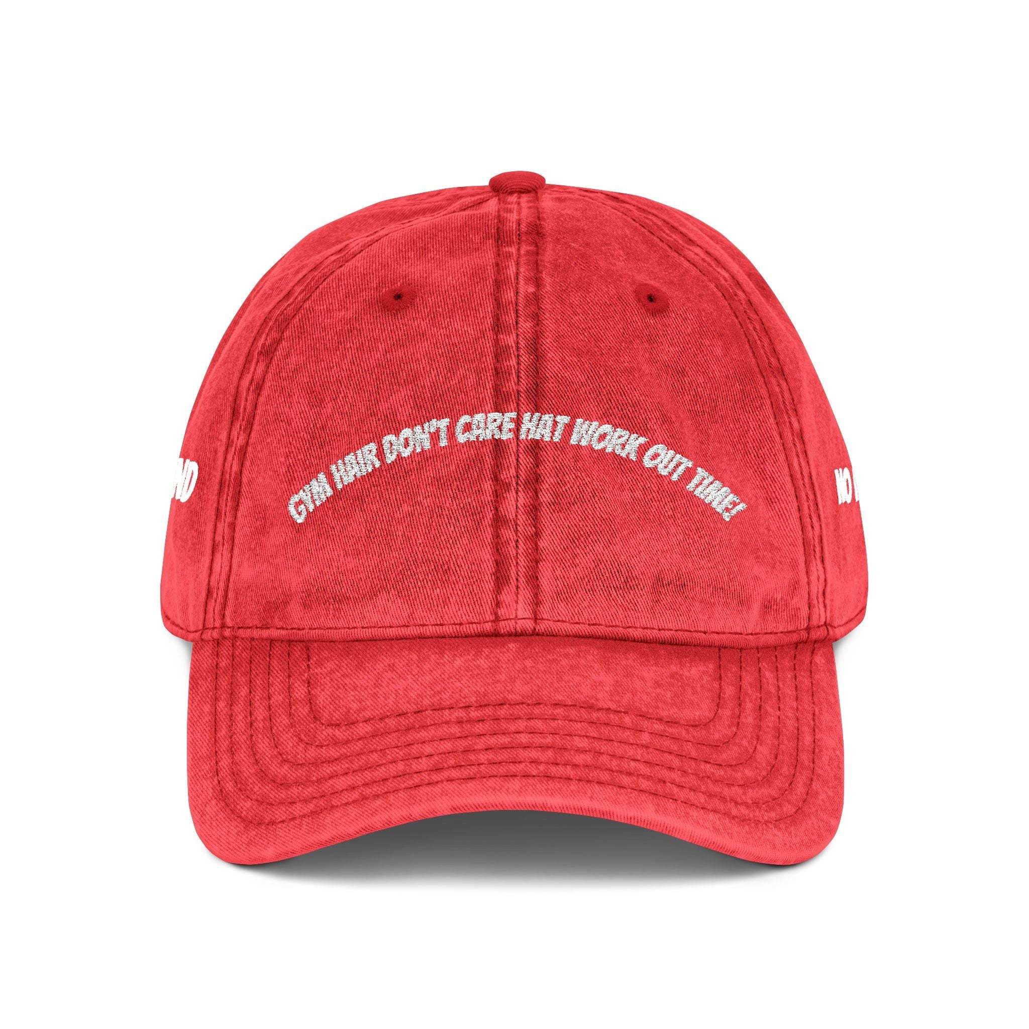 Red vintage embroidered cap with quirky slogan and washed-out effect, six-panel unstructured design, and adjustable antique-finished metal snap buckle.